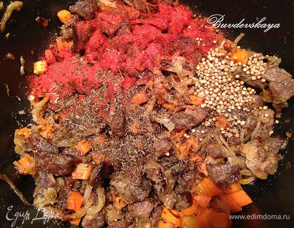 Когда лук станет прозрачным, добавить в казан морковь и перемешать. Обжаривать в течении нескольких минут помешивая. Затем посолить, поперчить, добавить по чайной ложке зиры , кориандра, паприки, острого перца на кончике ножа  и снова перемешать.