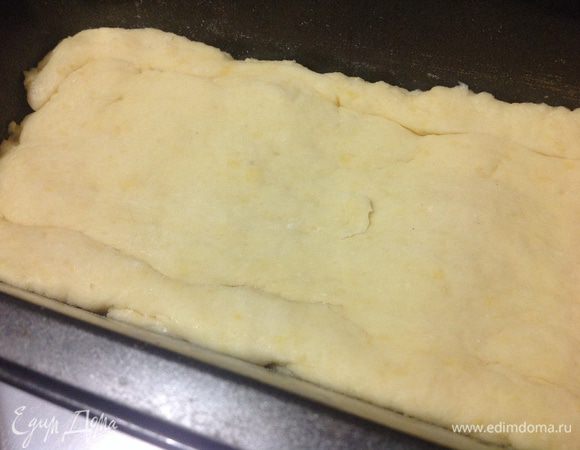 Достать тесто из холодильника, раскатать чуть больше по размеру, нежели форма, и выкладываем тесто сверху на бананы, подгибая внутрь края.
