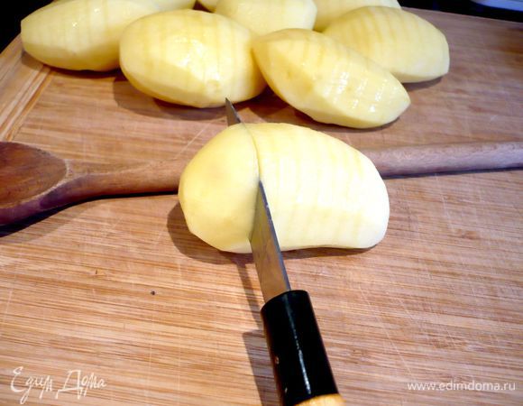 Разогреем духовку до 200 градусов. Картофель очистим. Теперь надрежем каждый картофель поперек через каждые 5 мм, прикладывая при резке к каждой картофелине деревянную ложку и надрезая до тех пор, пока нож не коснется ложки. Каждую картофелину смазываем оливковым маслом (нам потребуется примерно 3 ст.л.) и посыпаем солью. 