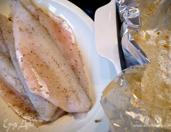 Филе рыбы (если честно, то я впервые использовала филе судака, оно оказалось безумно костлявым, поэтому в следующий раз приготовлю это блюдо со своим любимым красным окунем) промоем, оботрем бумажным полотенцем, посолим, поперчим и посыпем орегано. Форму для запекания выложим двумя листами фольги внахлест. Смажем 1 ст.л. оливкового масла и посыпем сухарной крошкой.