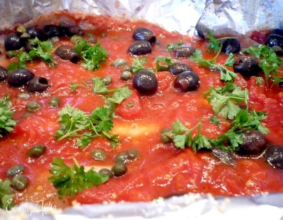 Выложим 2/3 соуса на фольгу, затем сверху рыбу, зальем остальным соусом, сверху выложим маслины, каперсы и посыпем порубленной петрушкой. Завернем фольгу. Выпекаем в течение 20 минут.