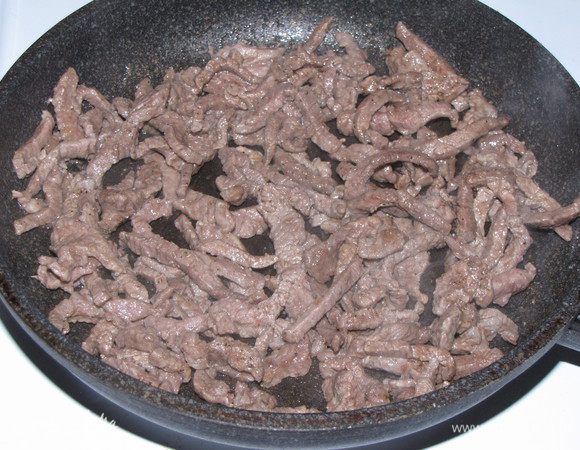  Телятину нарезать тонкой соломкой. Мясо лучше резать слегка подмороженным.  В сковороде разогреть 2 ст. л. растительного масла, выложить телятину и обжарить, помешивая, в течении 5 минут. Посолить и поперчить.