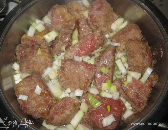 Разогреть в сковороде растительное масло, положить кусочки мяса и обжарить со всех сторон до образования корочки. Добавить мелко нарезаный лук и все слегка подрумянить.