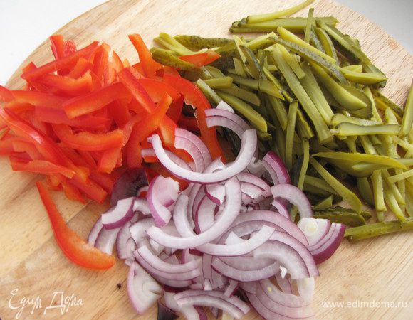 Перец разрезать на четыре части вдоль, почистить от семян, срезать толстые места и нарезать тонкой соломкой. Огурцы также нарезать тонкой соломкой, лук тонкими полукольцами.