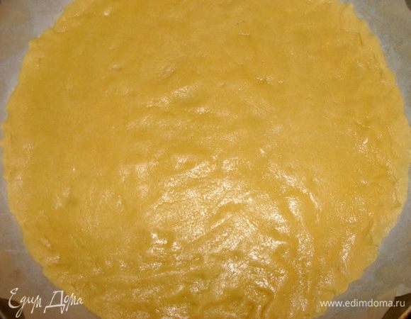 Форму для выпечки застелить пекарской бумагой. Распределить руками тесто. У меня форма 35 см. в диаметре.