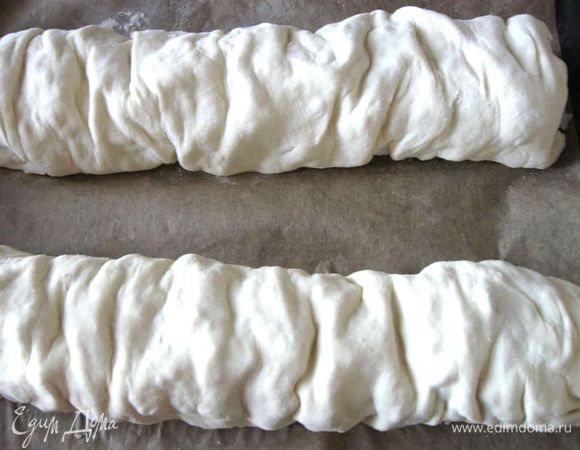 Свернуть рулеты, немного сморщив их. Противень застелить бумагой для выпечки, духовку разогреть до 230 градусов, поместить туда противень с двумя рулетами швом вниз. Желток отделить от белка. Через 10 минут после выпечки смазать рулеты желтком, смешанным с небольшим количеством воды (в процессе выпечки смазать желтком еще 1 – 2 раза).  Еще через 5 минут выпечки огонь убавить до 210 градусов и продолжать выпекать 25 минут. Общее время выпечки 40 минут.

