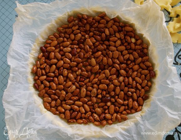 Выложить сверху пекарскую бумагу (фольгу) и засыпать сухой фасолью, горохом... Привычным для Вас "утяжелителем". Поставить в духовку на 20-25 минут. Готовый корж достать из духовки, снять гнет и бумагу. Понизить температуру духовки до 170 С. 