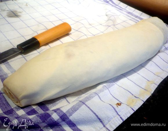 При помощи полотенца обернула рулет в это раскатанное тесто. 