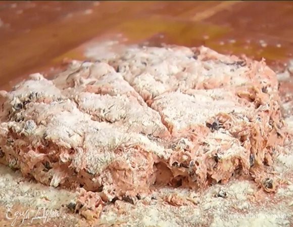 Рабочую поверхность присыпать 1 ст. ложкой муки, выложить тесто (оно довольно липкое) и вымесить руками. Придать тесту круглую форму, посыпать его мукой и сделать сверху ножом крестообразный надрез (можно надрезать на 8 частей).