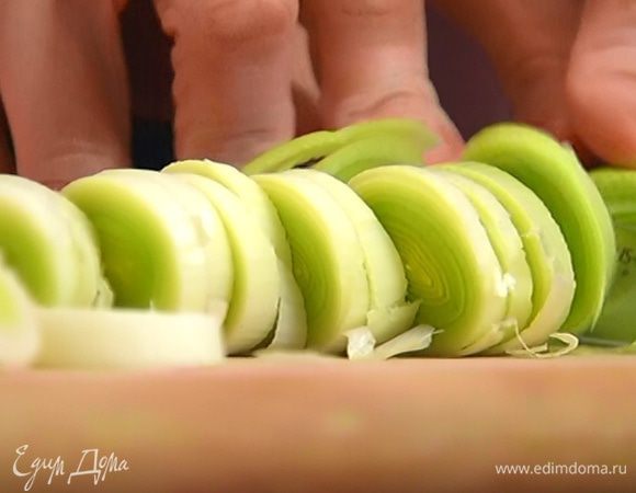 Светлую часть лука-порея порезать кольцами.