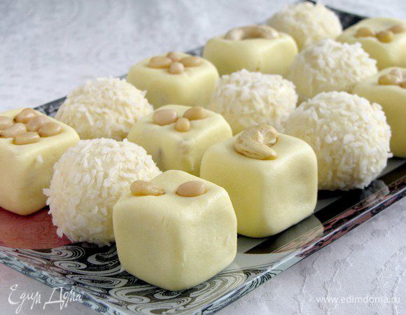 Затем выкладываем кокосовые шарики и молочные кубики на блюдо в произвольном порядке. Кубики украшаем кедровыми орешками. 