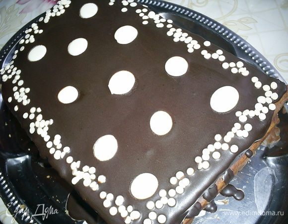 Затем кладем сверху второй пласт бисквита, срезом вниз. Снова шоколадный крем, бисквит срезом вверх, крем, бисквит срезом вниз. Бока торта обмазываем шоколадным кремом. Верх поливаем глазурью. Для глазури шоколад растопить со сливочным маслом, дать немного остыть и покрыть верх торта. Украсить по своему усмотрению, я использовала готовые диски и "капельки" из белого шоколада.