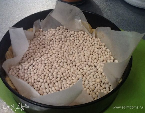 Разъемную форму смазываем маслом, выкладываем тесто, на тесто бумагу для выпечки,сверху горох и ставим выпекать в разогретую до 210 градусов духовку на 20 минут.