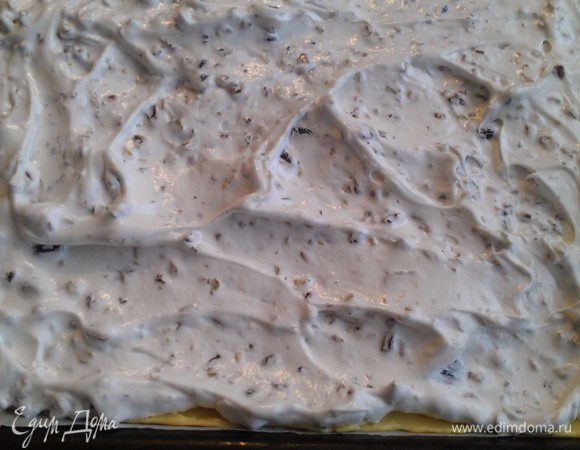 Духовку поставить разогреваться до 180-190 градусов. Приготовить 2 листа пергамента размером в противень. На пергаменте раскатываем  равномерно самую большую часть теста и кладем на противень. Сверху смазываем белковой массой.