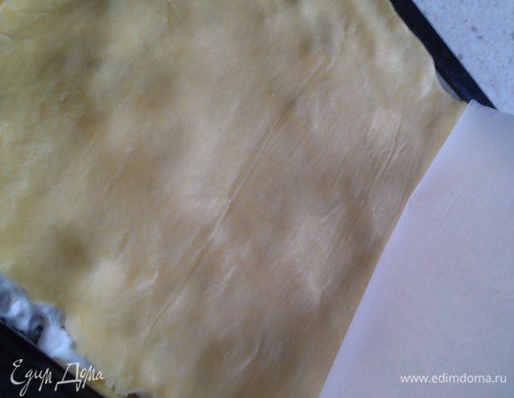 На 2 листе пергамента раскатываем 2 часть теста, аккуратно переносим обратной стороной на белковую массу и снимаем пергамент. Таким образом раскатать оставшиеся части теста промазанные начинкой.