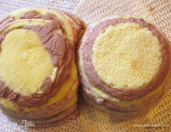 На блюдо или поднос выкладываем из мисок пропитавшиеся тортики. У большей полусферы вырезать небольшую выемку, для того чтобы плотнее приставить к ней меньшую полусферу.