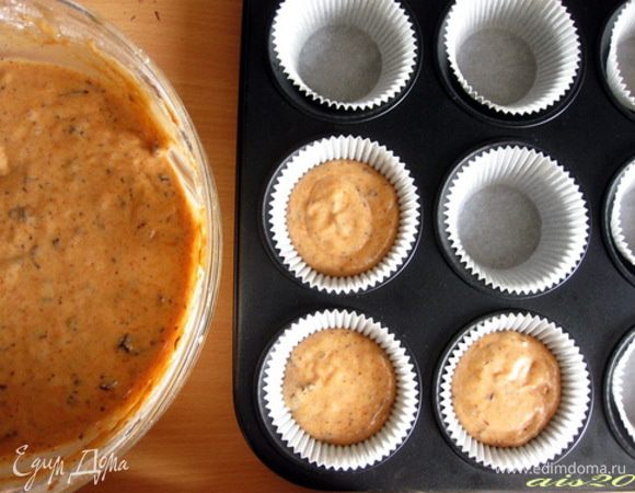 Духовку разогреть на 180о С.
Бумажные формочки вставить в форму для кексов, в каждую формочку выложить по столовой ложке теста.