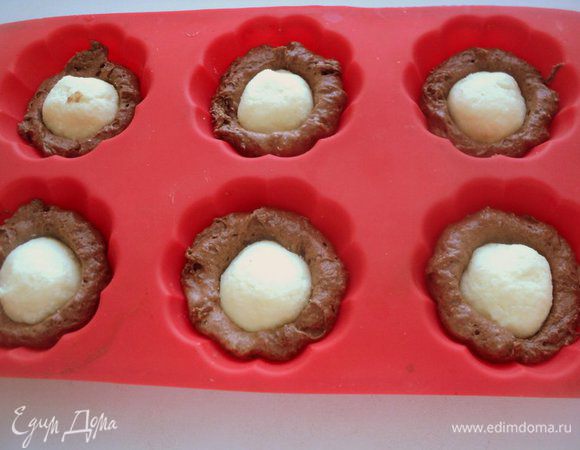 По середине уложить подмороженные творожные шарики, немного вдавив их.