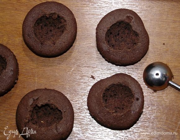 Затем ложечкой для фруктов вырезаем серединку капкейков.