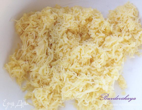 Картофель сварить в мундире, охладить, очистить и натереть на мелкой терке. Переложить в глубокую миску.