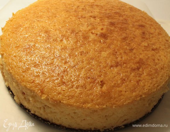 Готовый бисквит оставить в духовке на 5 минут, затем достать из духовки, убрать фольгу, опрокинуть вверх дном форму на лист пергамента и дать бисквиту слегка остыть, затем перевернуть форму, ножом пройтись вдоль бортика, снять ободок формы и дать бисквиту остыть.