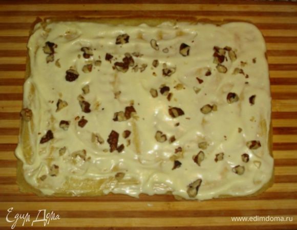 Первый корж смазать кремом и посыпать орешками. 
