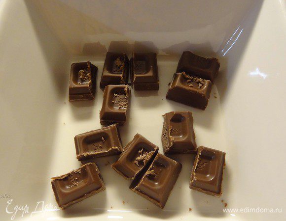 Я использовала молочный шоколад. Шоколад (100 грамм) разделим пополам. Одну половину поломаем на 12 маленьких кусочков.