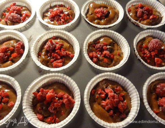 В каждый маффин положим кусочек шоколада, который мы ранее заготовили и 1 клубничку (если клубника крупная, то желательно порезать пополам). Ягоду можно класть мороженую, предварительно не размораживая. Я заменила клубнику на малину.

Поставим наши маффины в предварительно разогретую до 200° С духовку выпекаться примерно на 20 минут. 