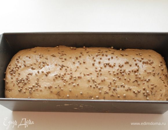 После подъёма выкладываем тесто в форму смазанную маслом, аккуратно выравниваем лопаточкой, (лопатку можно смочить водой) присыпаем тмином и кориандром. Закрываем плёнкой и оставляем ещё на 30-40 минут для подъёма.