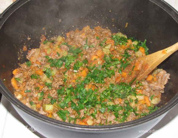 Добавить смесь специй, петрушку и кинзу.