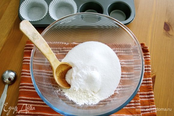 Включить духовку на 180 С. Форму для кексов выложить бумажными стаканчиками. В большой миске смешать муку, сахар, разрыхлитель, пищевую соду и соль; отставить в сторону.