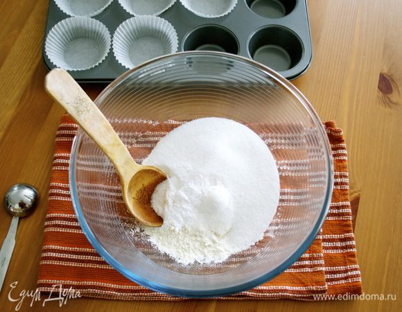 Включить духовку на 180 С. Форму для кексов выложить бумажными стаканчиками. В большой миске смешать муку, сахар, разрыхлитель, пищевую соду и соль; отставить в сторону. 
