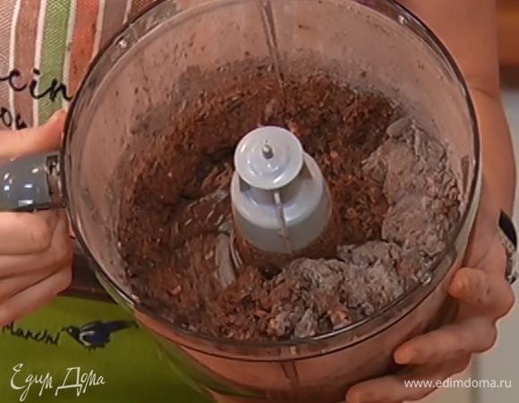 В чашу комбайна с тестом добавить измельченные орехи и шоколад, всыпать оставшуюся муку с какао и все вместе вымешать.