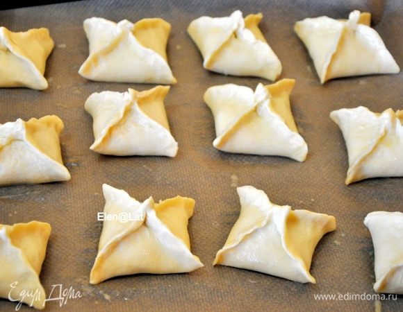 Пирожки выложить на противень, застеленный пергаментом, смазать взбитым яйцом. И выпекать в заранее разогретой до 180 С духовке примерно 25-30 минут. 