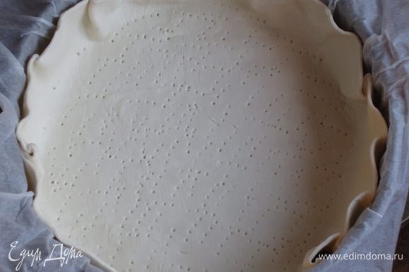 Пекарскую бумагу намочить водой , хорошо отжать и выстелить дно формы диаметром 24 см. Слоёное тесто раскатать в круг диаметром 30 см, выложить в форму и наколоть вилкой.Поставить в холодильник.