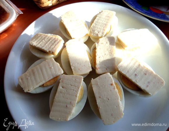 Сверху кладём по ломтику любого плавленого сыра или намазываем его, если он мягкий.