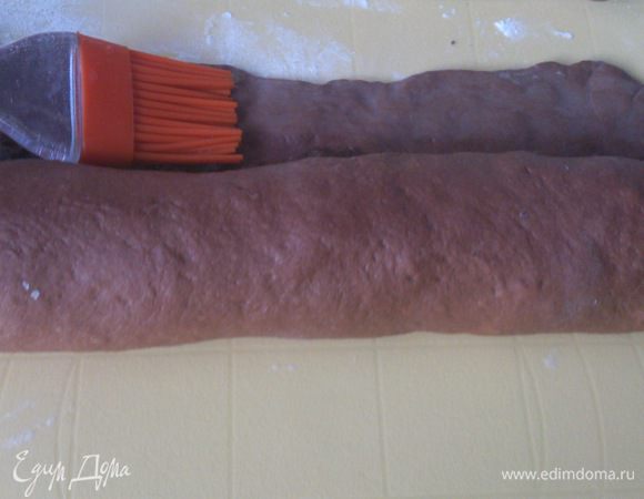 Край смазать взбитым яйцом и свернуть тесто в рулет.