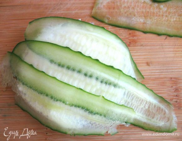 На хлеб со сливочным сыром внахлест положить пластинки огурцов. Аккуратно перевернуть, вырезать по контуру. Можете поступить проще, намазав целый кусок хлеба мягким сыром, положить таким же образом огурец, вырезать формочкой.