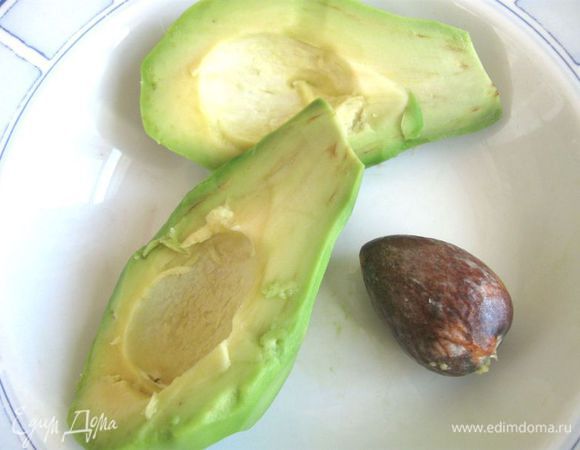 Посыпать специями, украсить зеленью, например, листиком кориандра.
Из авокадо, порезанного на половинки, удалить косточку, почистить. 
