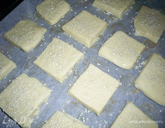 Выкладываем печеньки на противень, застеленный пергаментом. Смазываем слегка взбитым белком и посыпаем кунжутом. Отправляем в предварительно разогретую до 180-190 градусов духовку, где наши печеньки проведут примерно 20 минут. Они должны приобрести приятный золотистый цвет и сильно вырасти в высоту.