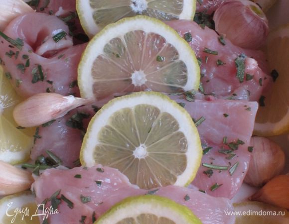 Выложить в форму неочищенный чеснок, лимон, залить вином и запекать в разогретой до 180 °С духовке 30 минут, затем поставить под гриль на 5 минут.