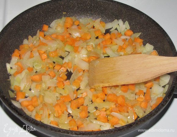Разогреть на сковороде 2 ст. л. оливкового масла и обжарить лук до прозрачности. Затем добавить нарезанную мелким кубиком морковь. Жарить еще 5-7 минут.