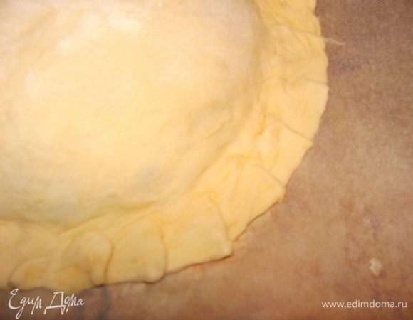 Сверху накрыть кругом из теста большего диаметра. Плотно прижать края, чтобы начинка не поддекла.