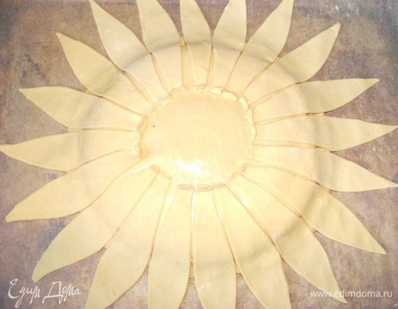 Из теста, предварительно раскатанного, вырезать "лепесточки" и выложить их на поверхность, смазанную белком. Края лепесточков, ближнии к центру, прищепить к основе.