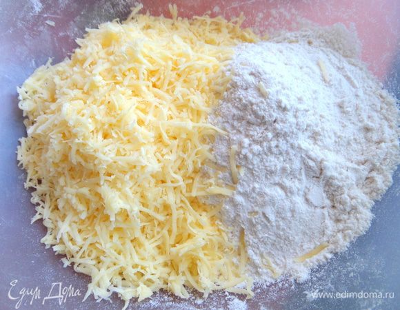 Смешиваем сыр с мукой (вначале 100 г муки,а потом добавим по мере необходимости).