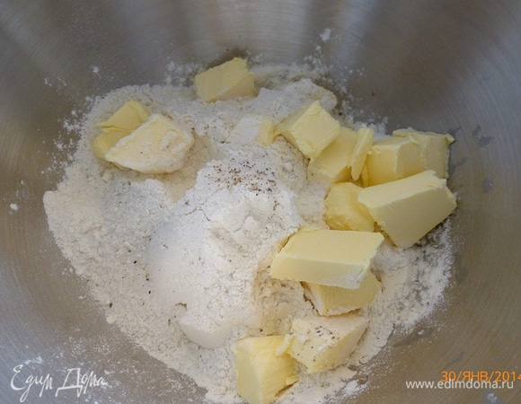 Готовим тесто. К муке добавляем сахар, соль, перец. Холодное сливочное масло режем на небольшие кусочки. Перетираем мучную смесь с маслом до образования крошек.