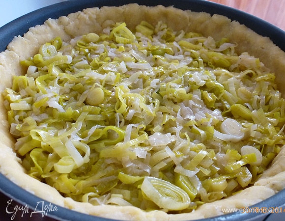Раскатываем тесто по размеру формы. Переносим тесто в форму, делаем бортики. У меня форма 22 см в диаметре. В последнее время тесто не раскатываю, а отрываю небольшие кусочки и выкладываю их как мозаику. Убираем в морозилку на 10–15 минут. Вынимаем форму из холодильника. Выкладываем лук.