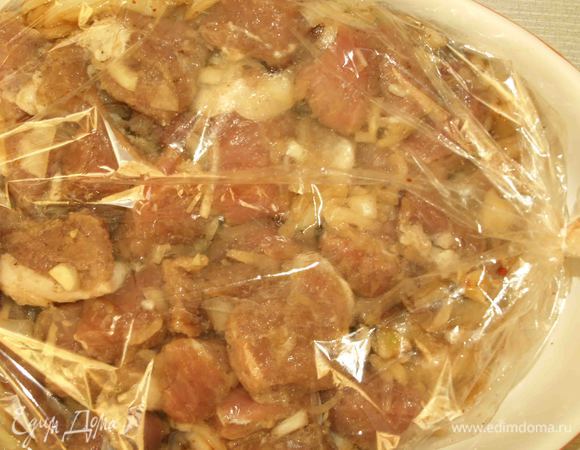 Когда мясо и лук замариновались берем рукав для запекания или пакет и отправляем первым лук. На лук (не перемешивая с луком) укладываем свинину. Завязываем пакет, прокалываем пакет в нескольких местах. Укладываем на противень или в жаропрочную посуду и отправляем в разогретую до 180 градусов духовку  на 1-1,5 часа. 