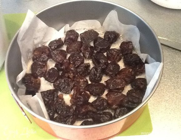 Разъемную форму застилаем бумагой для выпечки,обильно смазываем маслом, выкладываем чернослив (его нужно немного отжать).