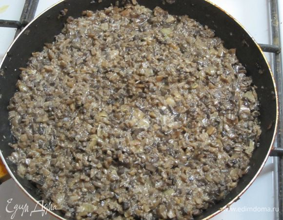 Выложить на сухую сковороду. Грибы должны отдать воду. Когда вода выпарится, влить 2 столовые ложки растительного масла, добавить мелко нарезанный лук. Перемешать и обжарить. Посолить, поперчить. Грибная начинка готова.